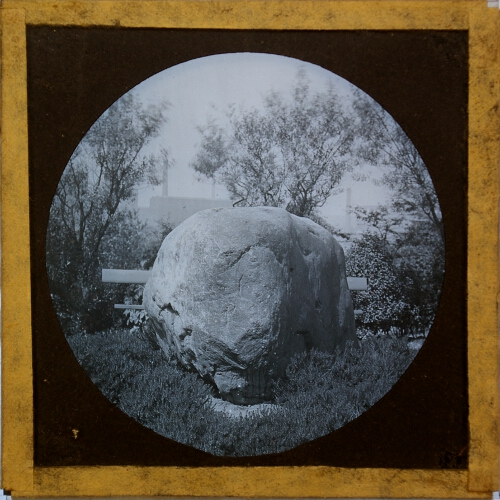 Large boulder with factory in background
