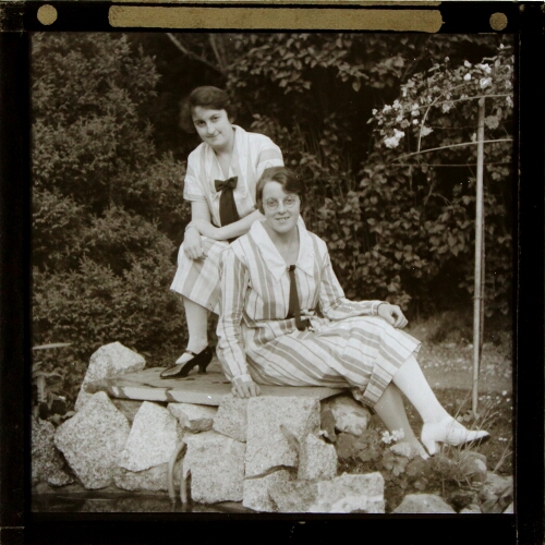 Two young women sitting in garden
