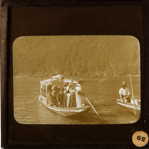 Men and women in local costume in boats on lake