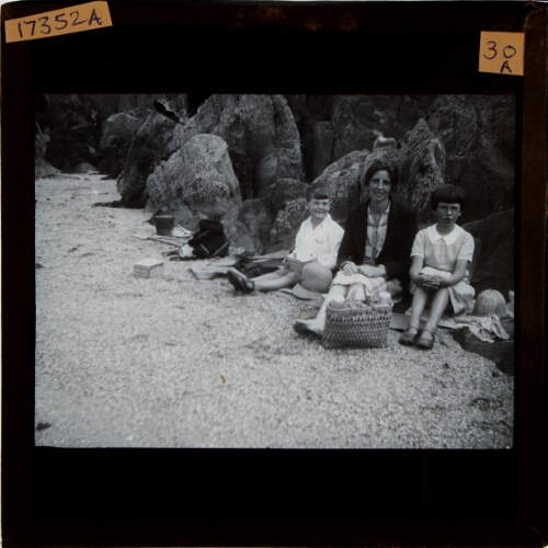 Woman, boy and girl sitting on beach