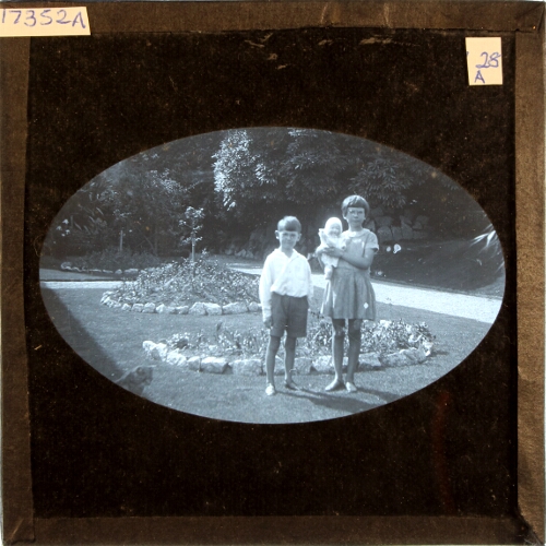 Boy and girl with doll in garden