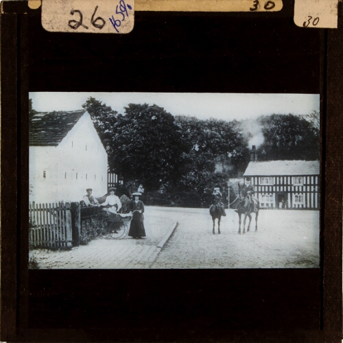 People and horses standing in village street