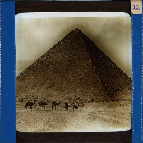 People riding camels in front of Egyptian pyramid