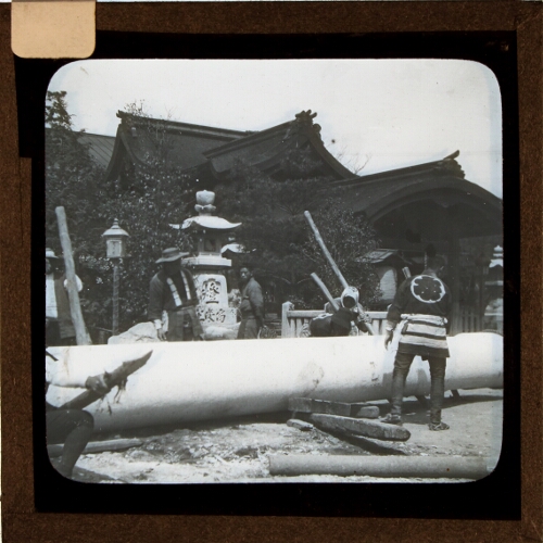 Group of men moving large column at temple