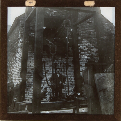 Man standing by shafts of pumping engine