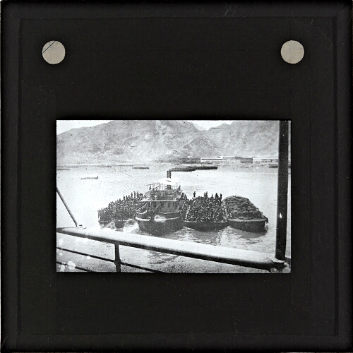 Group of men and horses being transported by river