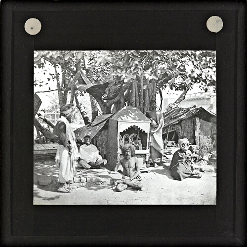 Group of men sitting around village shrine