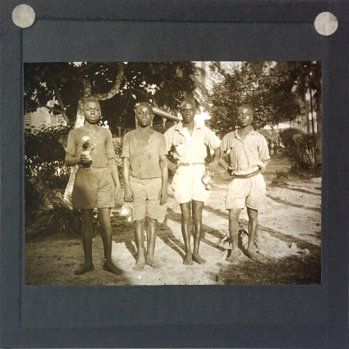 Group of four African men holding lamps