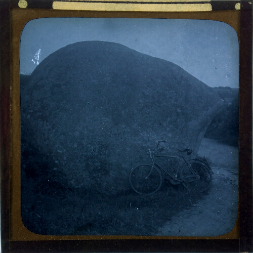 Bicycle leaning against large boulder