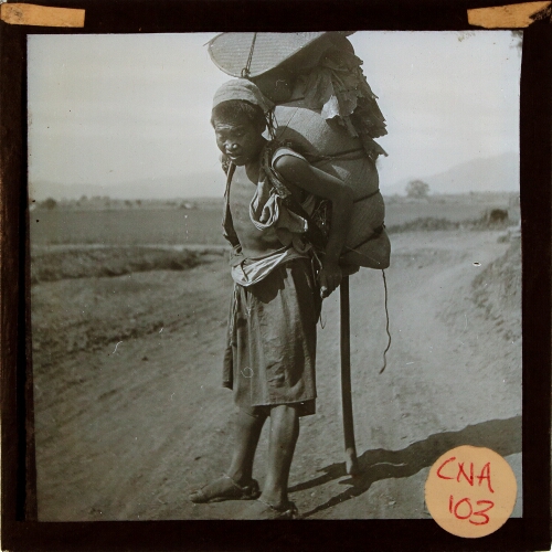Chinese man carrying large load on his back
