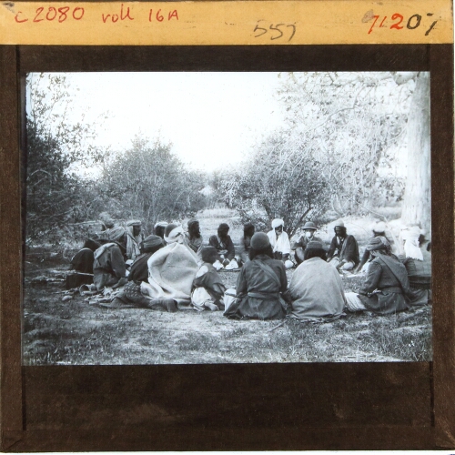 Group of men sitting in circle on ground