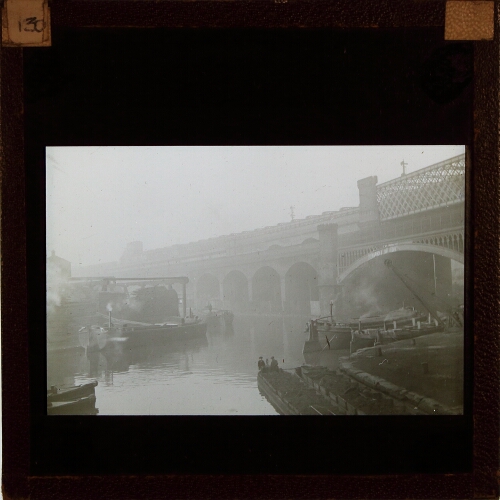 Barges on canal with railway bridges in background