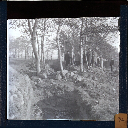 Group of men among trees with trench in foreground – secondary view of slide