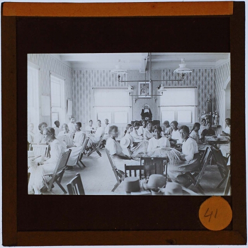 class room supervised by nun, people braiding baskets (?)