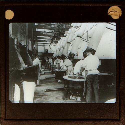 Men mixing unidentified material in factory