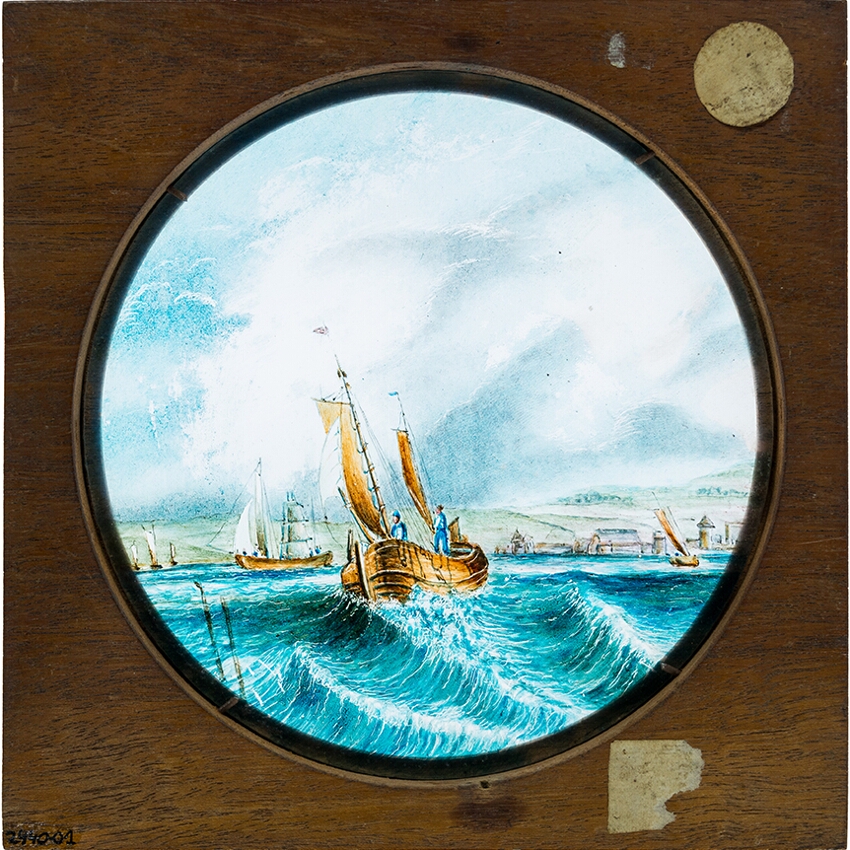 Sailing ships on sea with coast in background