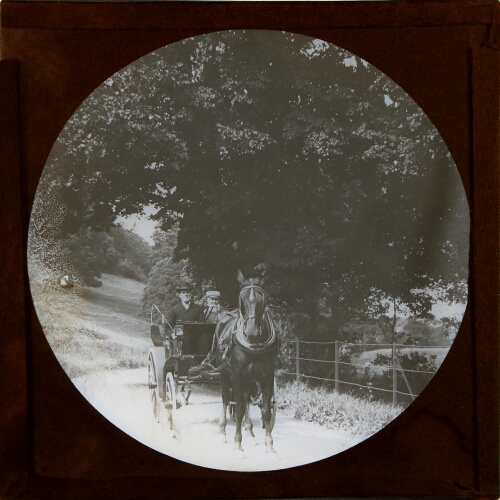 Two men riding in horse-drawn carriage