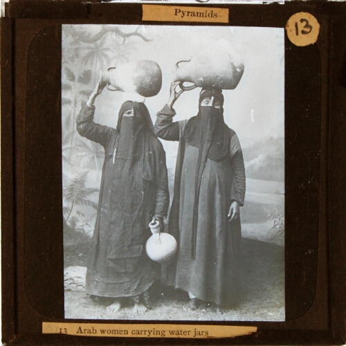 Arab women carrying water jars