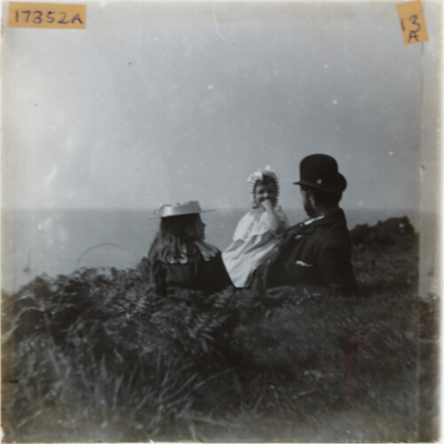 Man and two girls lying on cliff top
