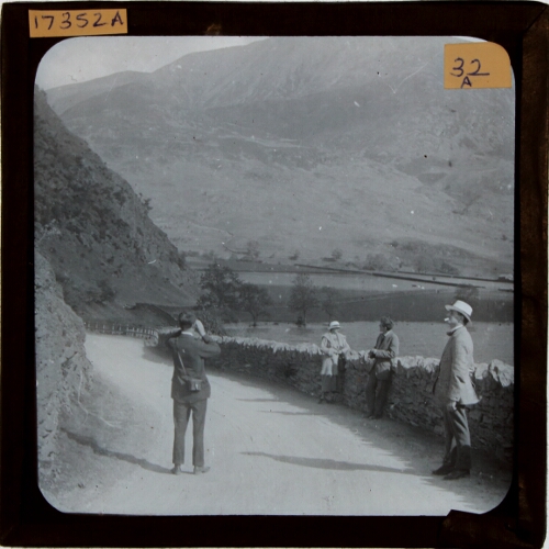 Four people on road in mountainous landscape