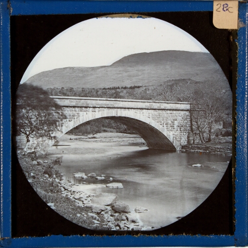 Unidentified bridge over river in rural landscape