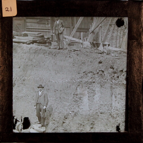 Two men standing in archaeological excavation site