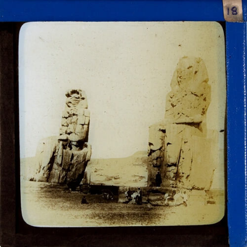 Two ancient Egyptian statues in desert landscape