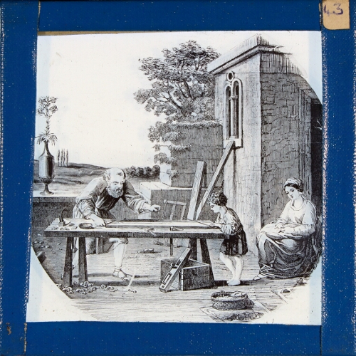 Man and boy working at carpenter's bench watched by woman
