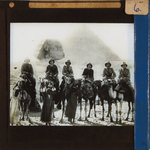 Six British Army officers riding camels by Sphinx and Pyramids of Gizeh