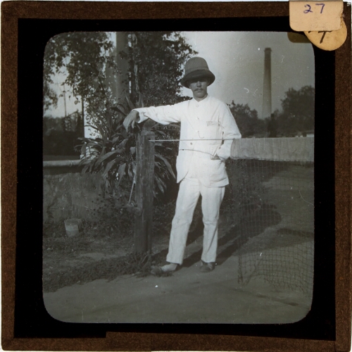 Man wearing colonial helmet posing on tennis court