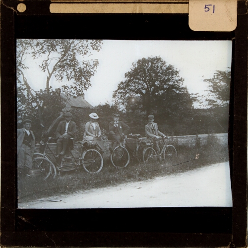 Group of people with bicycles resting by side of lane