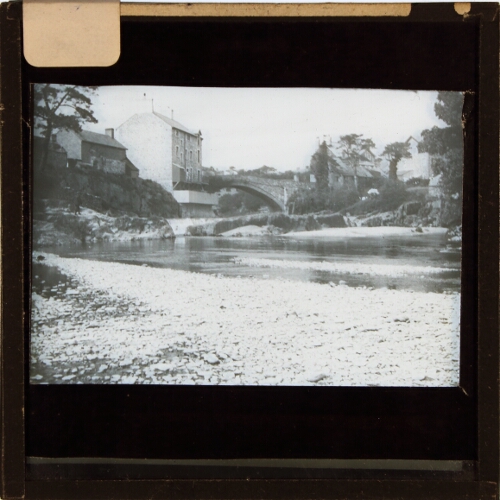 Bridge across river at unidentified town or village