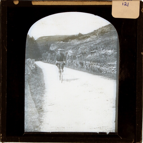 Man cycling on lane in moorland landscape