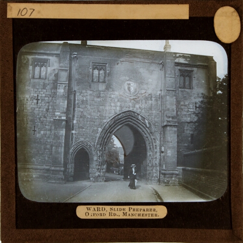 Woman walking through archway of unidentified gatehouse