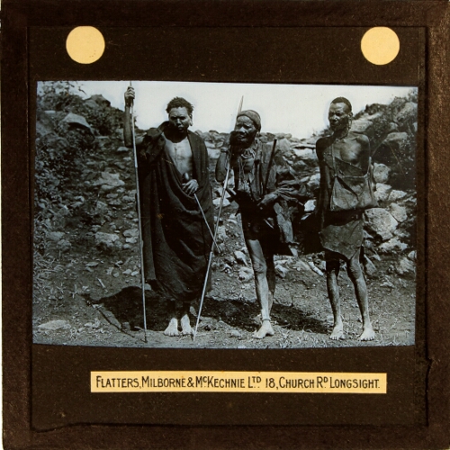 Three African men standing in front of wall