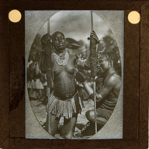 African man attaching jewellery to woman