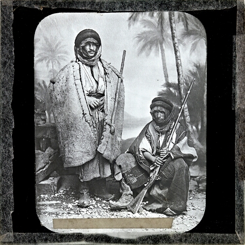 Two tribesmen, one holding rifle