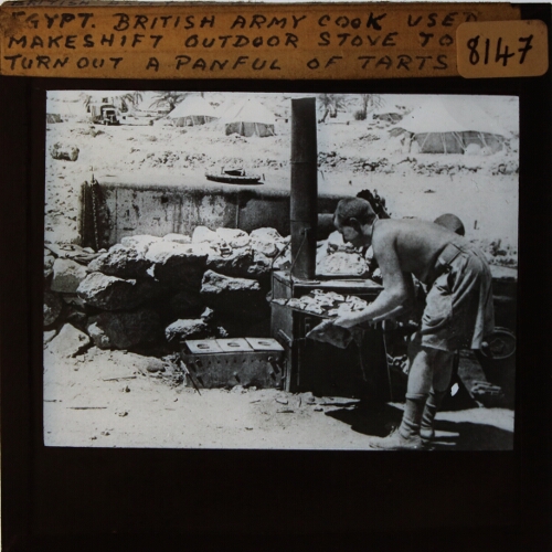 Egypt -- British Army cook used makeshift outdoor stove to turn out a panful of tarts