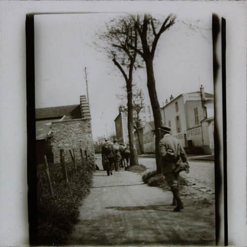 Group of men walking in street in French town or village