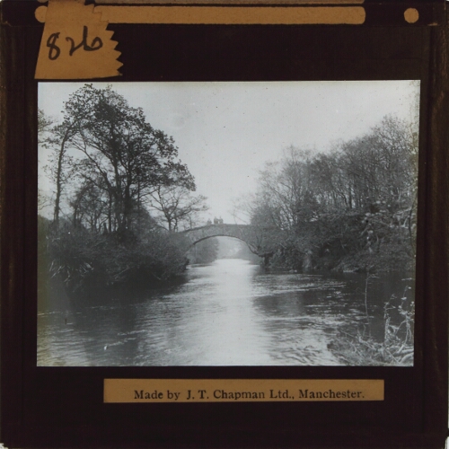 River with men standing on bridge in middle distance