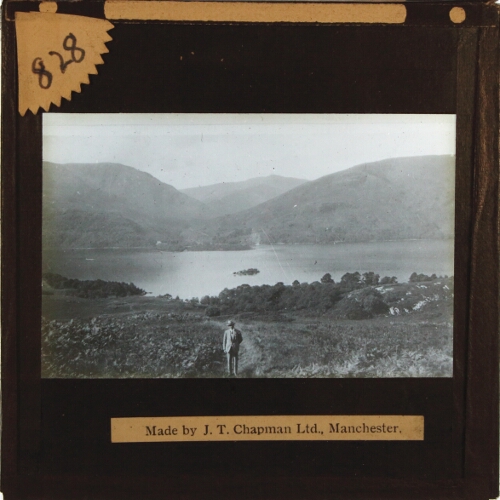 Man standing in landscape with lake and hills