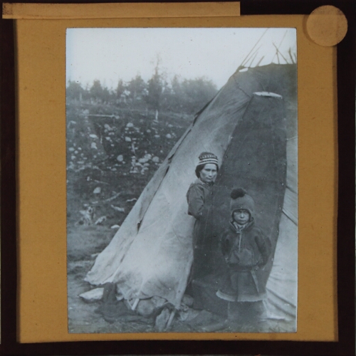 Woman and child wearing Lapp costume at entrance to tent