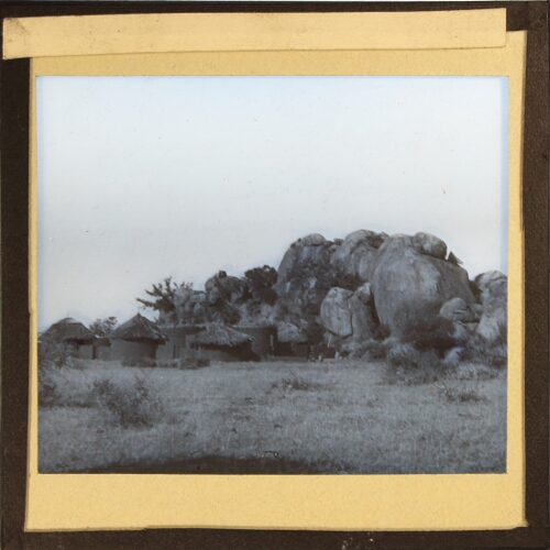 Huts and enclosure by group of large rocks