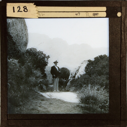 Man and dog standing on path in rural location