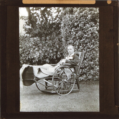 Wounded soldier in wheelchair in gardens, Alderley Park