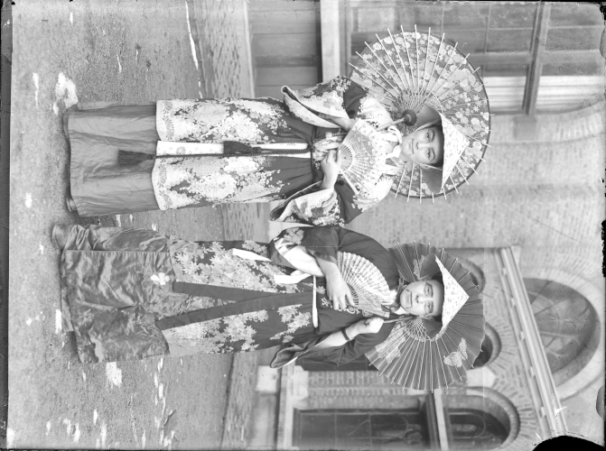 Two men wearing 'oriental' fancy dress costumes