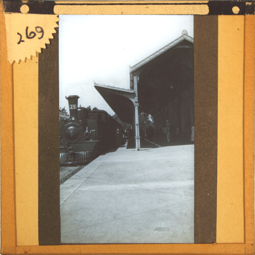 Locomotive and train standing at unidentified railway station