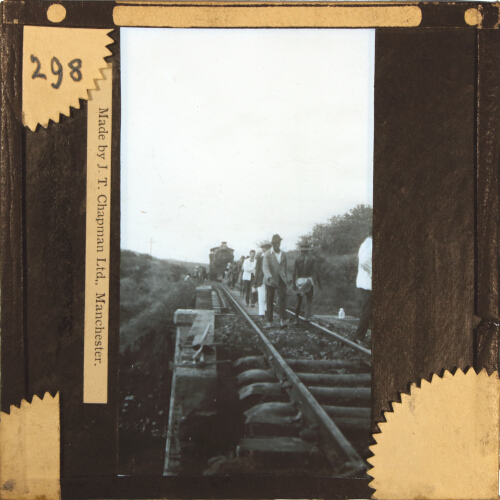 Group of people walking away from train on railway track