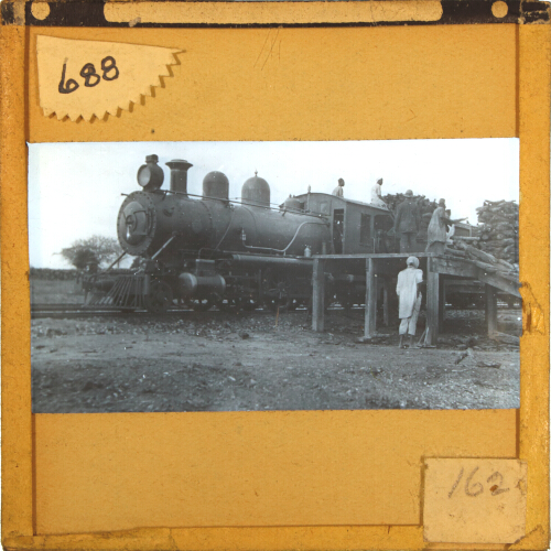 Railway locomotive being loaded with firewood