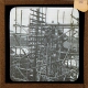 [Men working in scaffolding structure by telegraph pole]